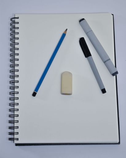 A top view of a notebook with eraser, pen, pencil and marker