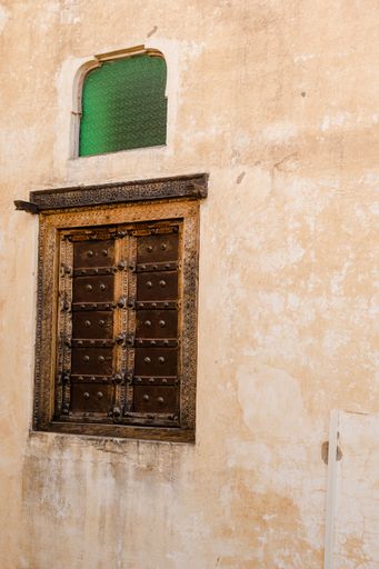 A vertical shot of an old gate on the wall of a historic structure