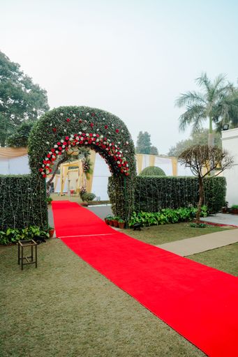 An arch with red carpet on the entrance floor for the wedding