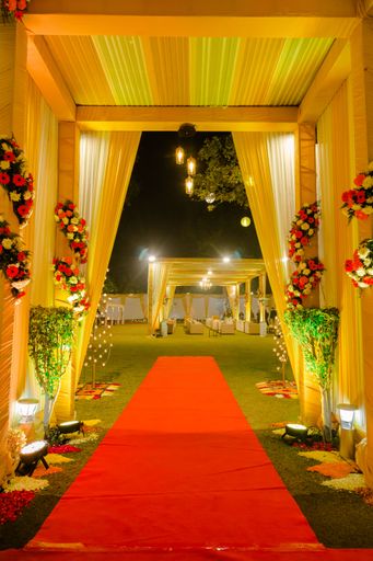 An arch with red carpet on the entrance floor for the wedding