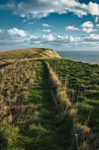 An idyllic landscape of lush green rolling hills that lead down to Isle of wight island