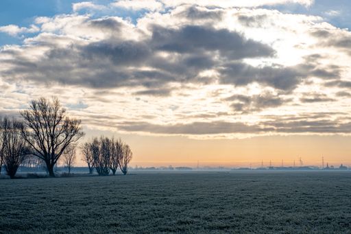 A beautiful shot of a field at sunset under the cloudy sky