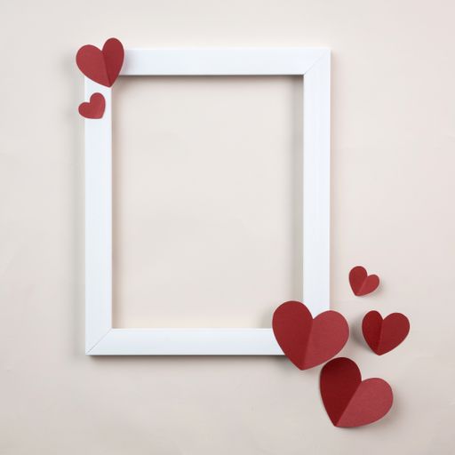 A closeup shot of frame and paper hearts against a white background with copy space
