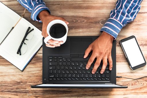 A top view of a businessman drinking coffee and working on a project
