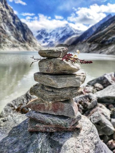 A vertical selective shot of stones stacked on one another at a rocky shore, concept of Balance and tranquility