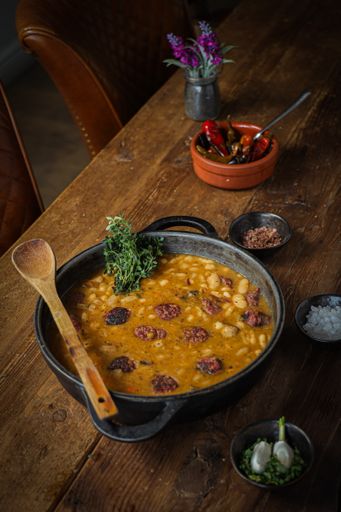 A vertical high angle shot of delicious homemade veal sausage with beans and hot pepper