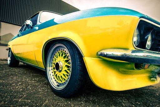 A closeup shot of a yellow and blue car during daytime