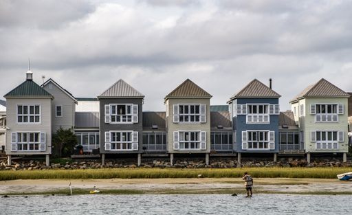 A wide angle shot of several small buildings next to each other under a cloudy sky