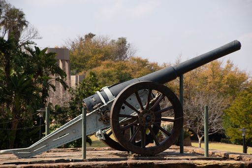 A beautiful shot of an old cannon in a park being displayed on a sunny day