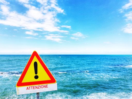 A beautiful seascape with a warning sign in the foreground