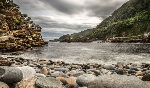 A wide angle shot of the beach around the mountains under a cloudy sky
