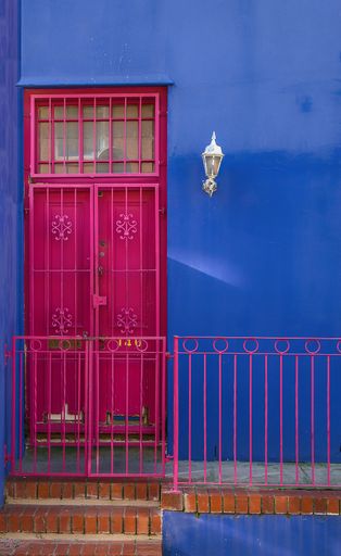 A closeup shot of the purple door of a blue building