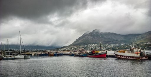 A wide angle shot of ships around the mountains under a cloudy sky