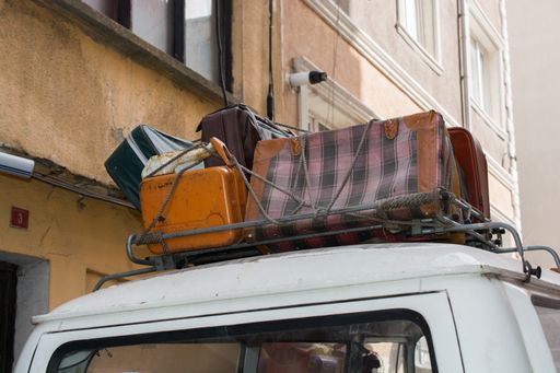 A low angle shot of luggage and suitcases strapped on a car