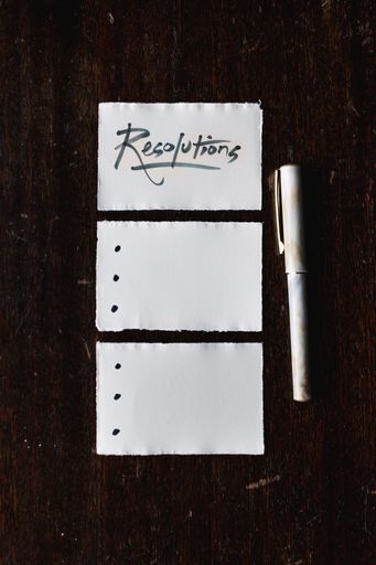 A vertical closeup shot of a piece of paper with resolutions written on it