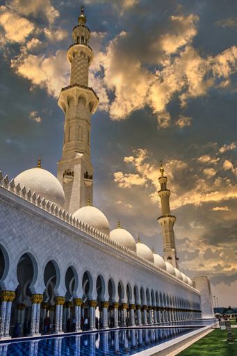The Sheikh Zayed Grand Mosque under a cloudy sky during a beautiful sunset in Abu Dhabi, United Arab Emirates
