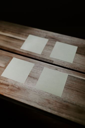 A vertical closeup of sticky note papers attached on a wooden table