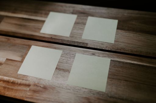 A top view closeup of sticky note papers attached on a wooden table