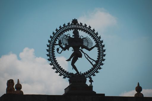 A low angle shot of the silhouette of a statue of an ancient goddess captured during the daytime