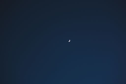 A beautiful shot of the moon in the waxing crescent phase in the clear blue sky