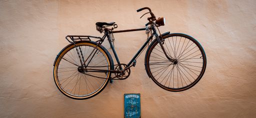 A closeup shot of a bicycle with a sign below it on a brown