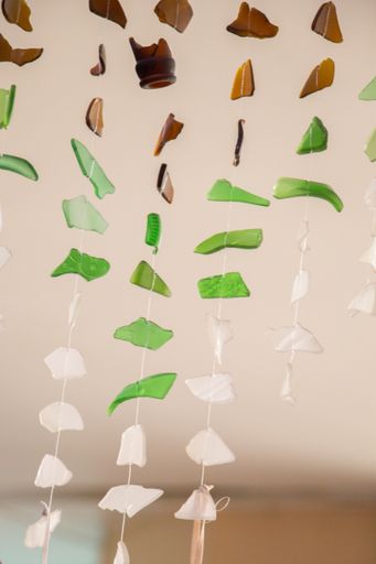 A vertical shot of pieces of broken glass tied on a string