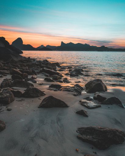 A beautiful shot of the rocky coast of the sea at sunset with amazing blue sky