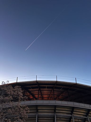A stunning vertical view of an airplane flying over a stadium