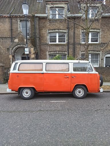 A vertical shot of an old classic van vehicle parked outdoors on a street