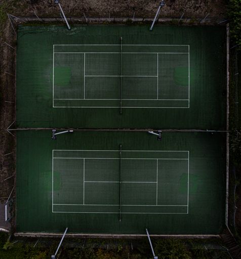 A vertical top view of two tennis courts