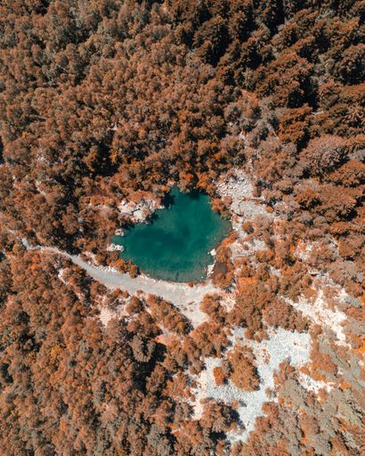 A vertical top view of a beautiful blue lake in the forest