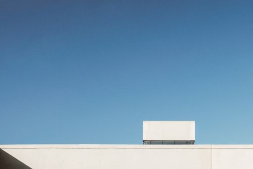 A wide angle shot of a part of a white building under a cloudless sky