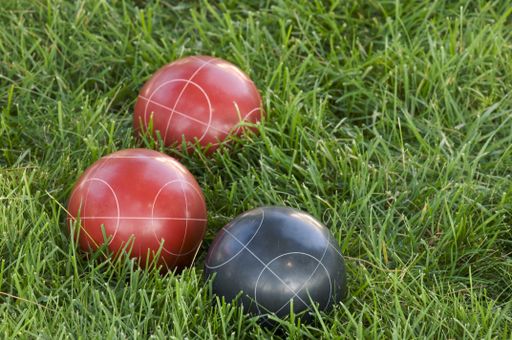 A vertical picture f colourful bocce balls on the lawn under the sunlight