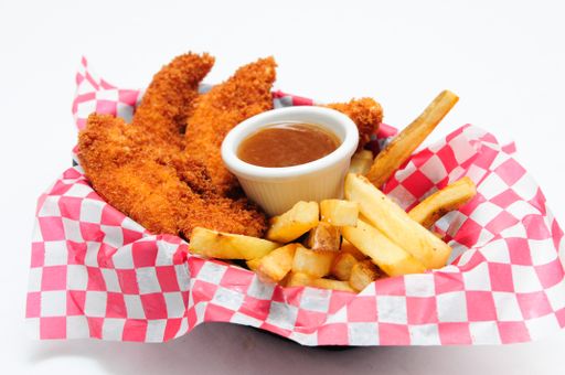 breaded chicken strips with french fries and dipping sauce in a diner basket