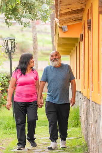 A Hispanic retired couple in sportswear walking outdoors and keeping a healthy lifestyle