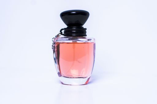 A transparent glass perfume bottle isolated on white background.