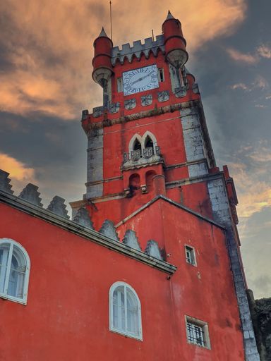 A vertical low-angle shot of the vibrant Pena Palace in Sintra, Portugal at sunset