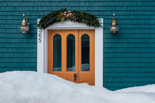 A beautiful house entrance with Christmas decorations blocked by snow