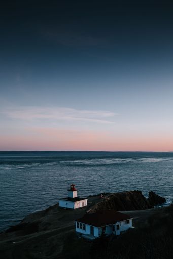 A vertical shot of the seascape with a lighthouse on the shore