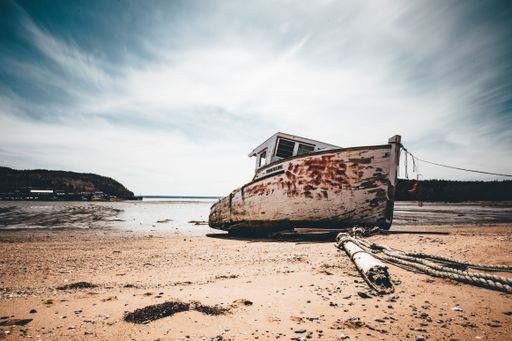 A beautiful view of a sandy beach with a boat on it in a sunny weather