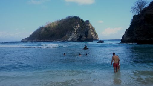 view from the beach on a small rock island in the ocean at ATUH BEACH, the best beach on NUSA PENIDA, Bali, Indonesia on 22th JULY 2019 at 2:49 pm