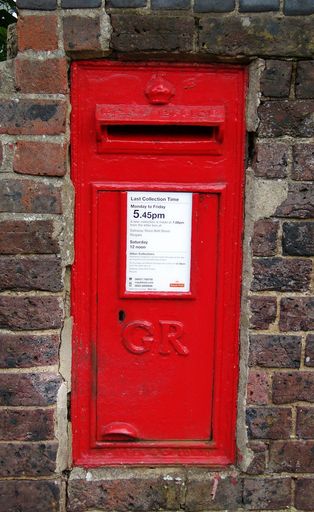 British Royal Mail red post box (set in a brick wall, dating from the reign of King George V, typical of post boxes in rural locations.