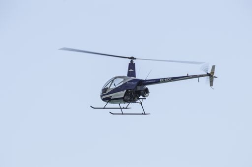 Detail of flying little helicopter bicolor, blue and white. Robinson R22