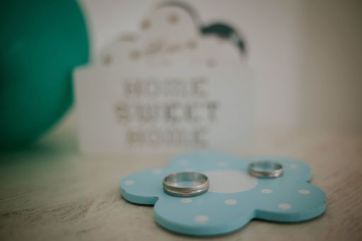 A selective shot of wedding rings on the decorative blue and white flower's surface