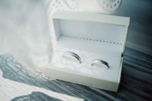 A closeup of wedding rings in a box on the table under the lights