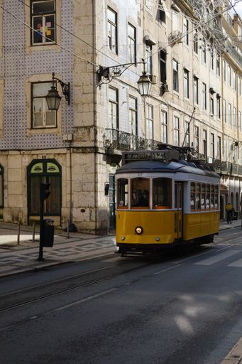 A vertical shot of a typical yellow tram in Lisbon, Portugal