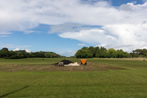 A vast, open expanse of land with a sandy pit situated in its center