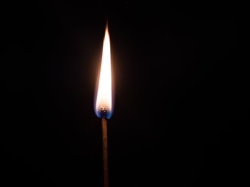 A closeup shot of a lit match stick with a black background