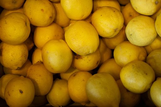 A closeup shot of a lot of lemons in a box - great for a cool background