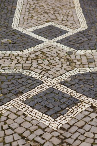 A vertical high angle closeup shot of a patterned cobblestone ground with tiles of different colors